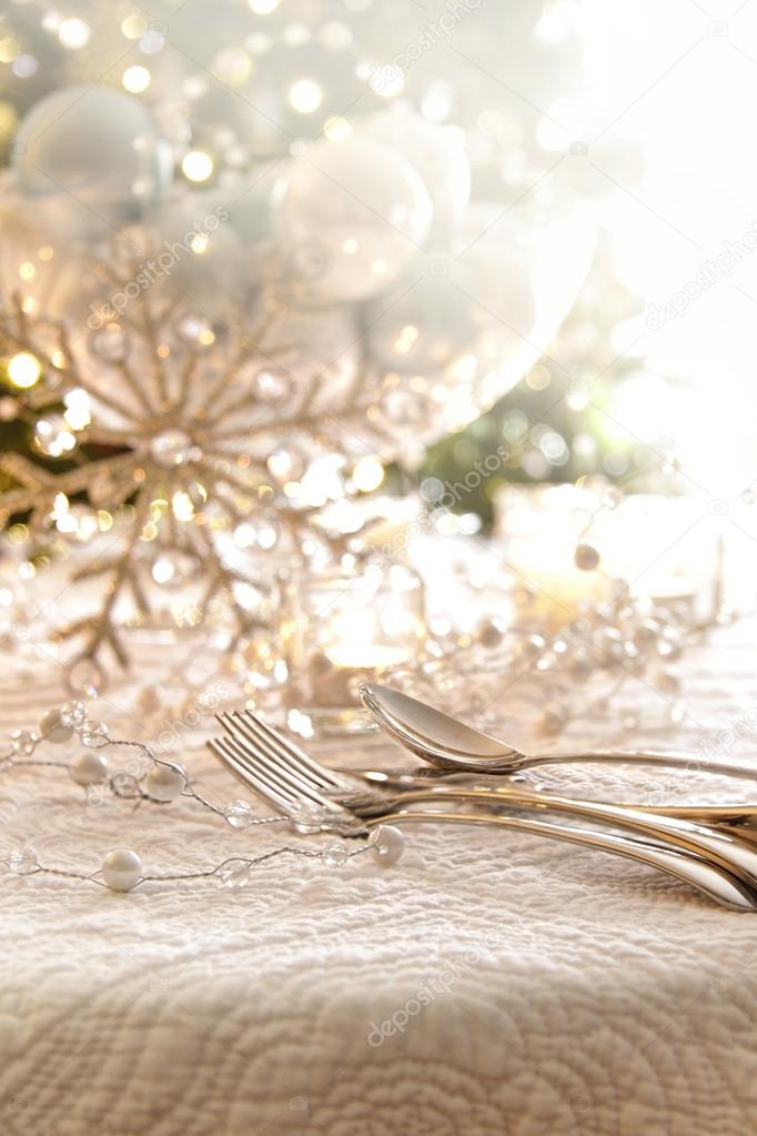 Elegantly lit holiday table with focus on pearl beads and utensi