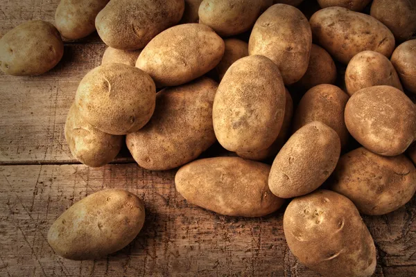 Batatas frescas no fundo de madeira — Fotografia de Stock