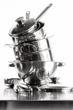 Stack with stainless steel pots and pans on white clipart