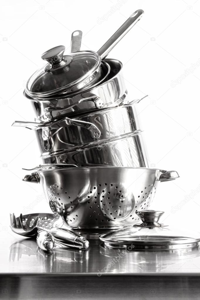 Stack with stainless steel pots and pans on white