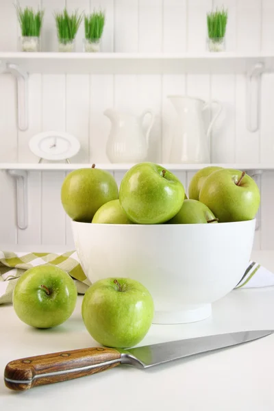 Green apples with blossoms on table — Stock Photo, Image