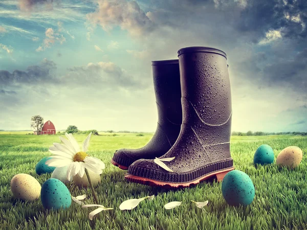Rubber boots with easter eggs on grass — Stock Photo, Image