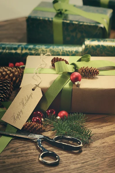 Regalos con etiqueta para las fiestas en mesa de madera — Foto de Stock