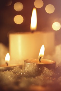 ıslak kar içinde yanan mumlar