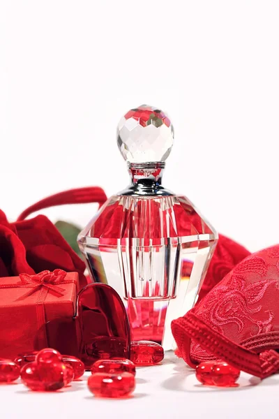 Бутылка духов, розовый и красный бюстгальтер на День Святого Валентина — стоковое фото