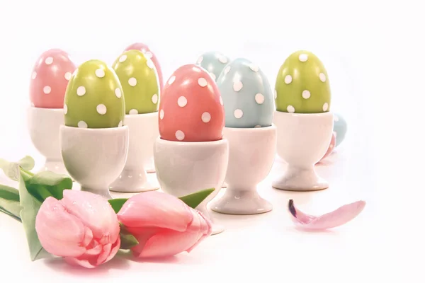 Цветные пасхальные яйца в белых чашках — стоковое фото