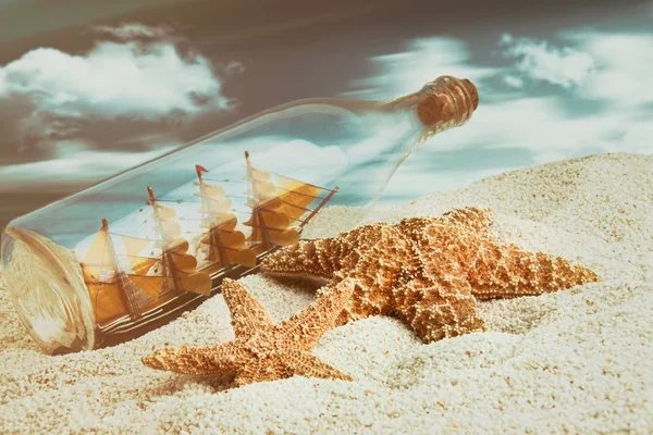 Fles met schip binnen op het strand — Stockfoto