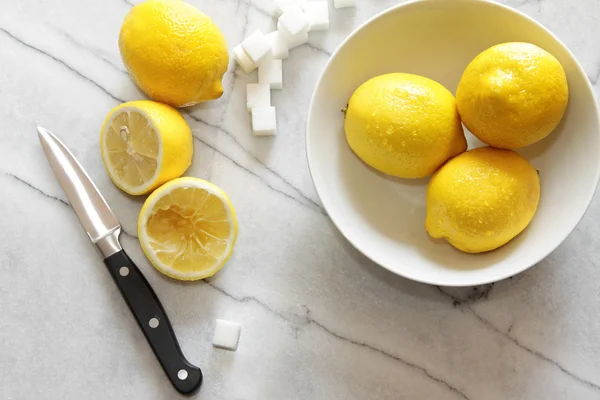 Frische Zitronen und Zuckerwürfel auf Marmortheke — Stockfoto