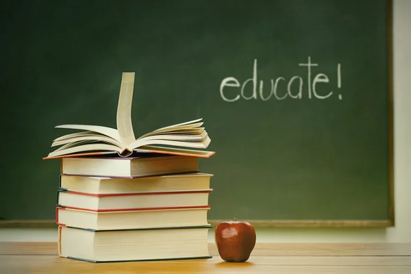 School books and apple on desk — Stock Photo, Image