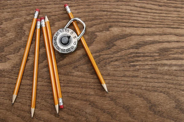 铅笔和木材表面上的锁 — 图库照片