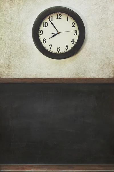 Uhr und Tafel mit notleidender Wand — Stockfoto