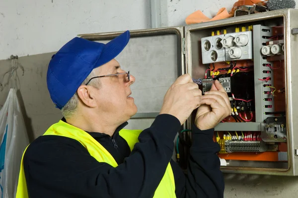 Senior elektriker kontrollera den elektriska panelen — Stockfoto