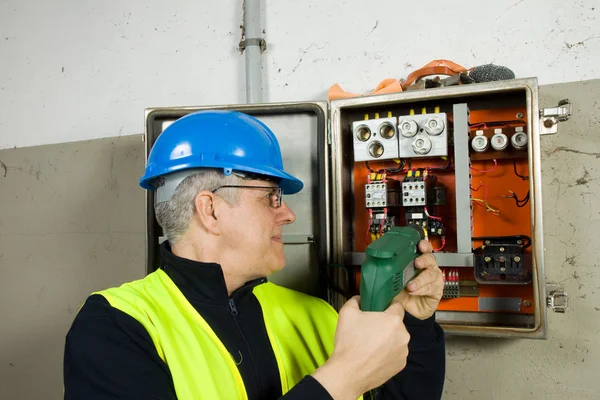 Eletricista sênior verificar o painel elétrico — Fotografia de Stock