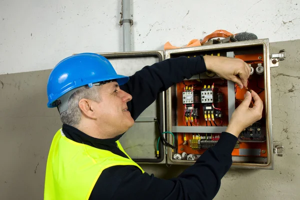 Eletricista sênior verificar o painel elétrico — Fotografia de Stock