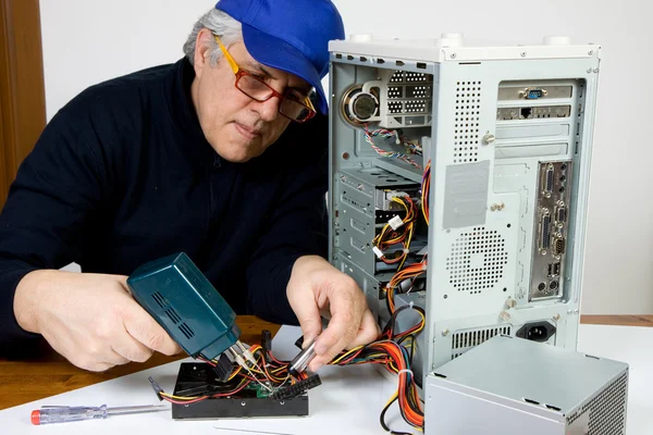 Senior electrician repairing processor — Stock Photo, Image