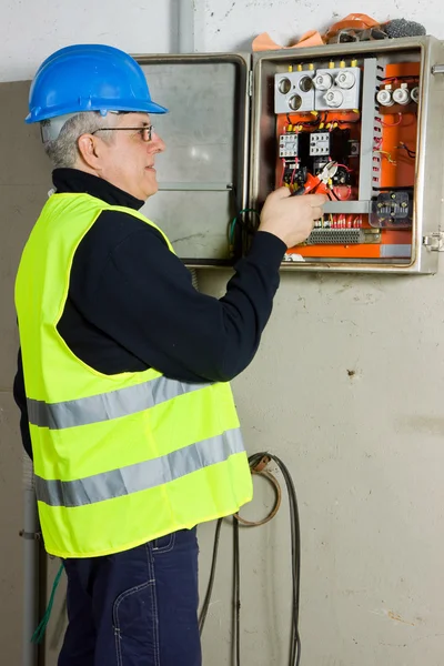 Eletricista sênior verificar o painel elétrico — Fotografia de Stock