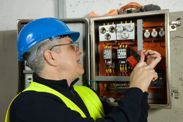 Senior elektriker kontrollera den elektriska panelen — Stockfoto