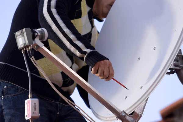 L'homme fixe une antenne parabolique — Photo