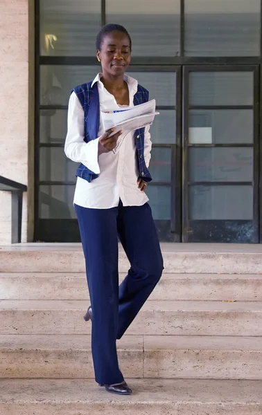 Student reading newspaper in campus — Stock Photo, Image