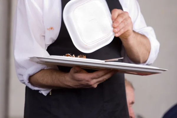 Servitören bär en bricka med mat — Stockfoto