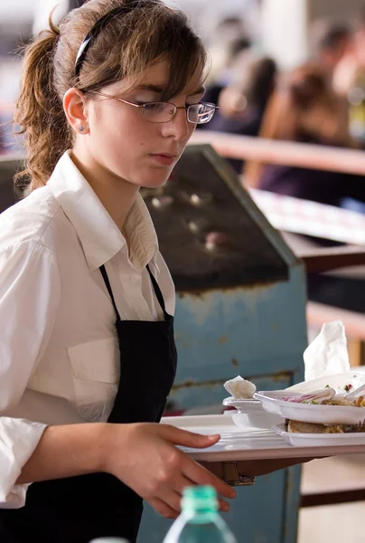 Servitrisen bär en bricka med mat — Stockfoto