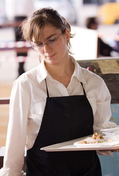 Servitrisen bär en bricka med mat — Stockfoto