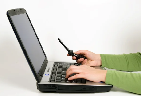 Frau benutzt Laptop und Handy — Stockfoto