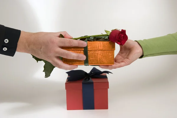 Man's hand gives rose and gift — Stock Photo, Image