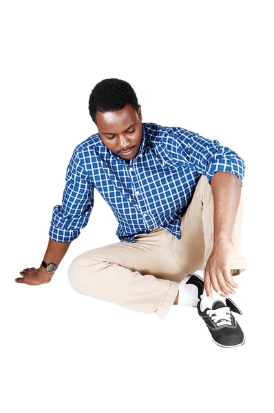 Черный человек, сидящий на полу . — стоковое фото