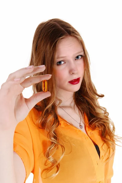 Mädchen zeigt Vitaminpille. — Stockfoto