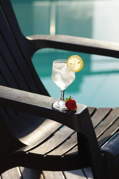 Swimming pool, lounge, a wine glass with ice, lemon and strawber — Stock Photo, Image