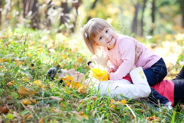 Belle jeune mère et sa fille couché sur la feuille d'automne — Photo