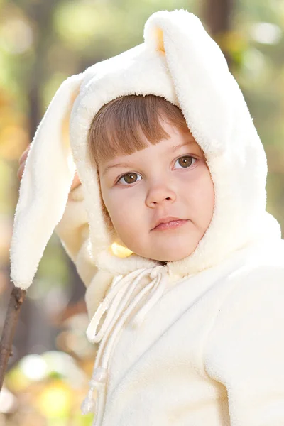 Красивая маленькая девочка в костюме кролика в осеннем лесу — стоковое фото