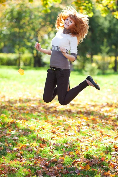 Juvping jonge redhead tiener vrouw in het bos — Stockfoto