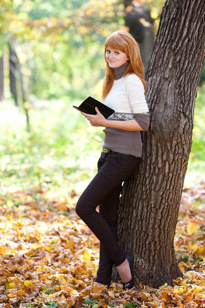 Portrait of a beautiful young redhead teenager woman reading a b — Stock Photo, Image