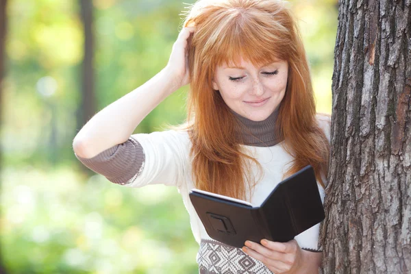 Retrato de una hermosa joven pelirroja adolescente leyendo un b —  Fotos de Stock