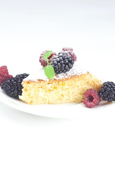 Coupe, gâteau, framboise, mûre, noix et menthe sur une assiette sur un w — Photo