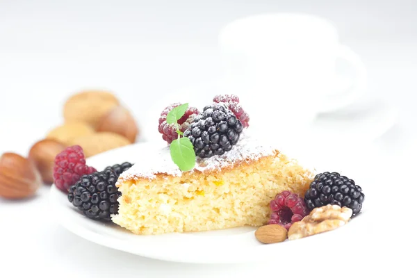 Coupe, gâteau, framboise, mûre, noix et menthe sur une assiette sur un w — Photo