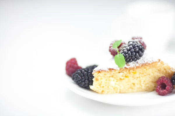 Coupe, gâteau, framboise, mûre, noix et menthe sur une assiette sur un w — Photo