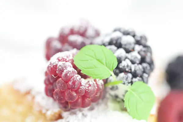 Cup, cake, raspberry, blackberry,nuts and mint on a plate on a w — Stock Photo, Image