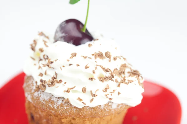 Muffin with whipped cream and cherry on white background — Stock Photo, Image