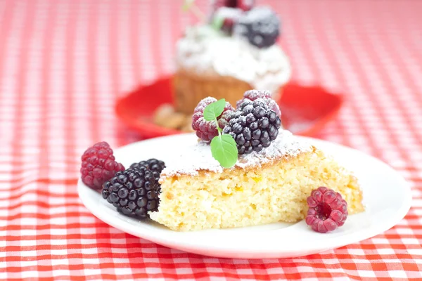 Muffin con crema batida, pastel con glaseado, frambuesa, blackberr — Foto de Stock