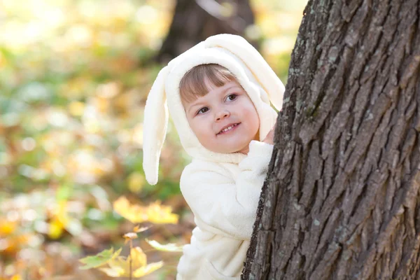 漂亮的小女孩在服装小兔子在秋天的森林中 — 图库照片