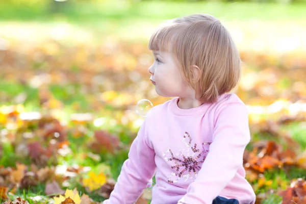 漂亮的小女孩坐在秋天叶子 — 图库照片