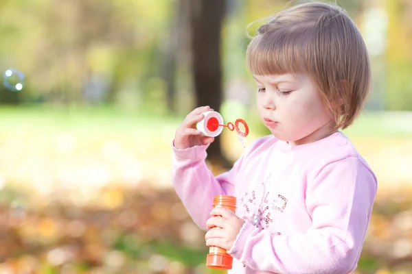 Bella bambina che fa soffiatore di bolle sulla foresta autunnale — Foto Stock