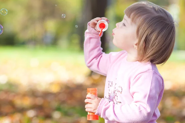 Güzel küçük bir kız Bubble blower sonbahar bir ormanda yapma — Stok fotoğraf