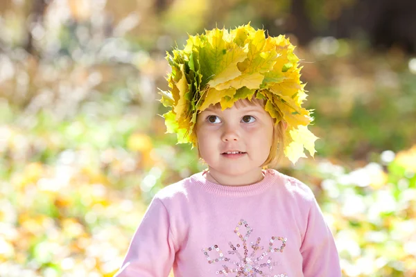 Szép kislány, a juhar koszorút levelek ősszel előtérbe — Stock Fotó