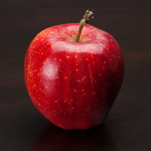 Rött äpple på ett träbord — Stockfoto