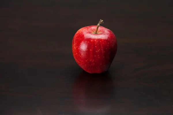 Roter Apfel auf einem Holztisch — Stockfoto