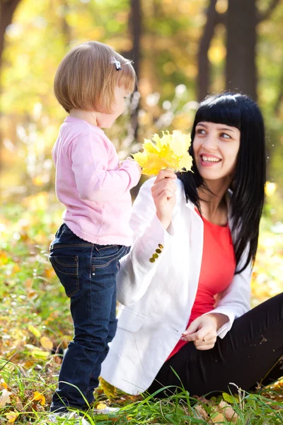 Beautiful young mother and her daughter on the autumv forest — Stock Photo, Image